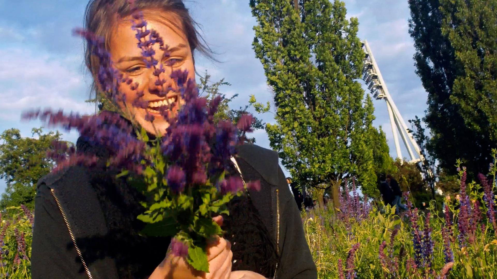 Eine lachende Frau mit einem Blumenstrauß in den Händen
