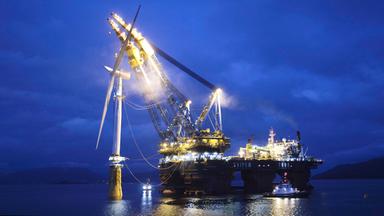 Riesiger Schwimmkran hebt ein Offshore-Windrad zur Montage auf seinen Sockel