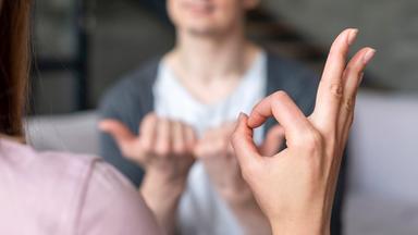 Zwei Menschen unterhalten sich in Gebärdensprache