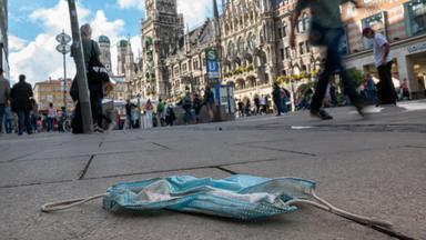 Eine getragene Mundschutzmaske liegt auf der Straße