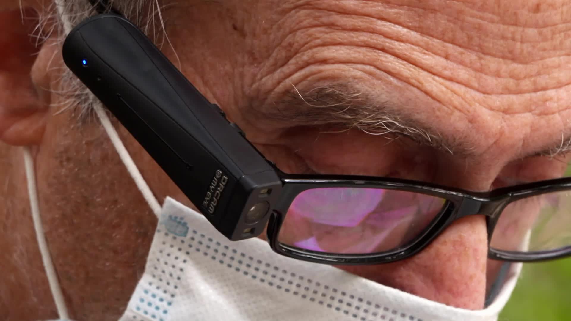 Ein Mann trägt eine Brille der Firma "OrCam", welche es ihm erlaubt, Texte zu lesen