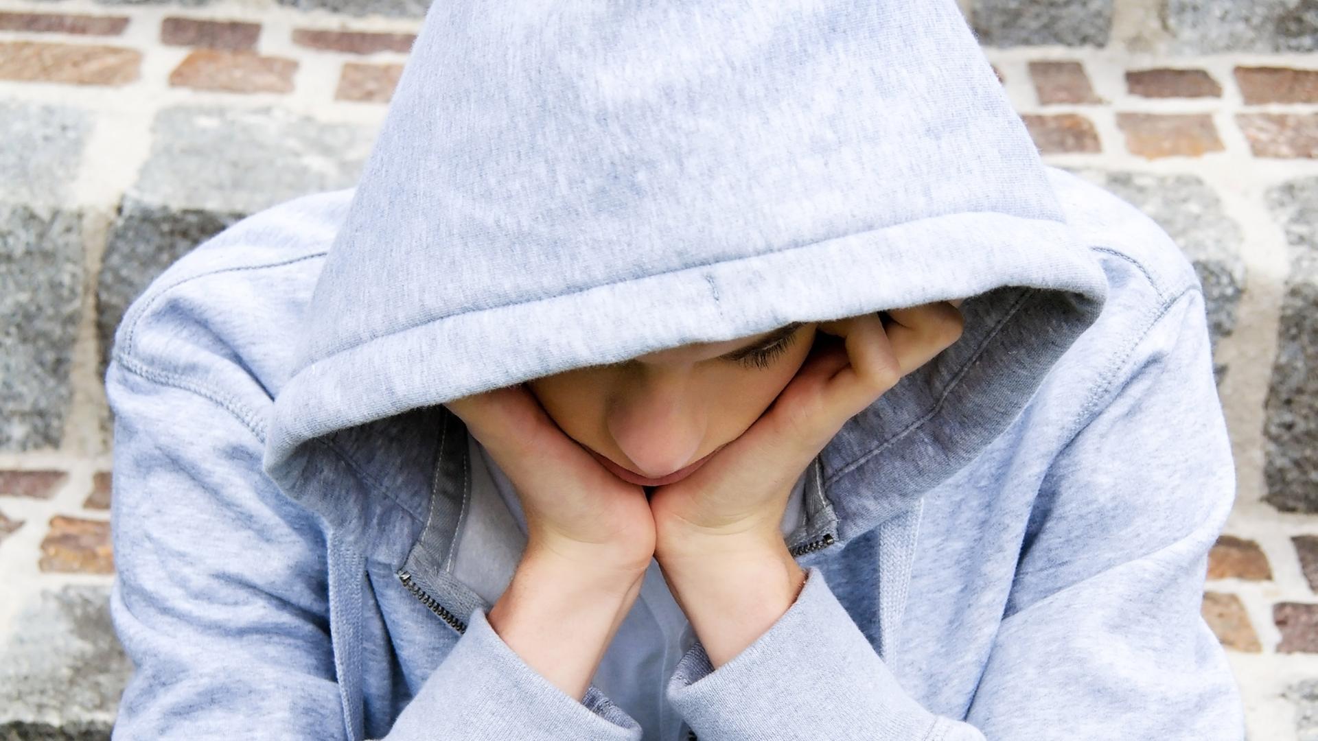 Jugendlicher sitzt am Boden