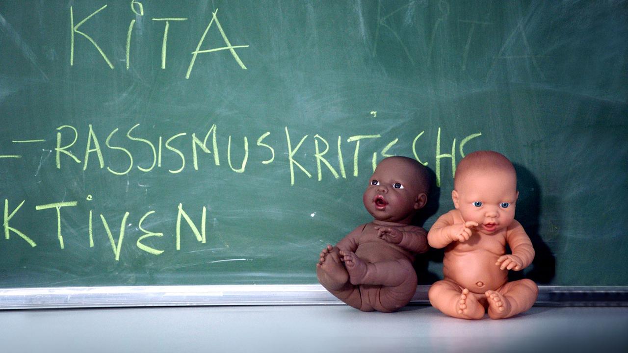 Puppen vor einer Tafel