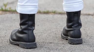 Symbolbild eines Mannes mit weißer Hose und schwarzen Stiefeln