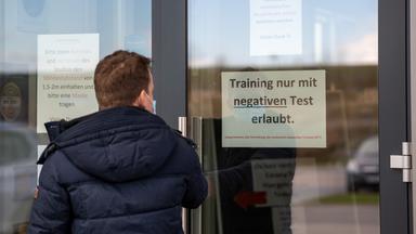 Mann stehrt vor Eingang zu Fitnessstudio