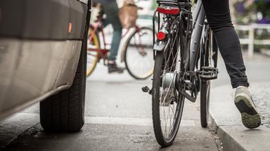 Fahrradfahrer neben Auto
