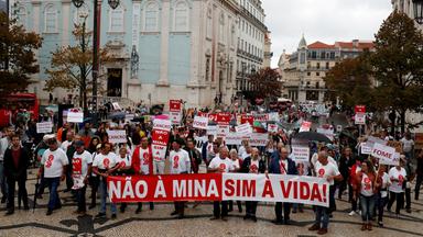 Prostest auf Straße gegen Lithium Abbau. Menschen tragen Transparent mit Aufschrift