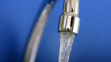 Wasser läuft in ein Glas