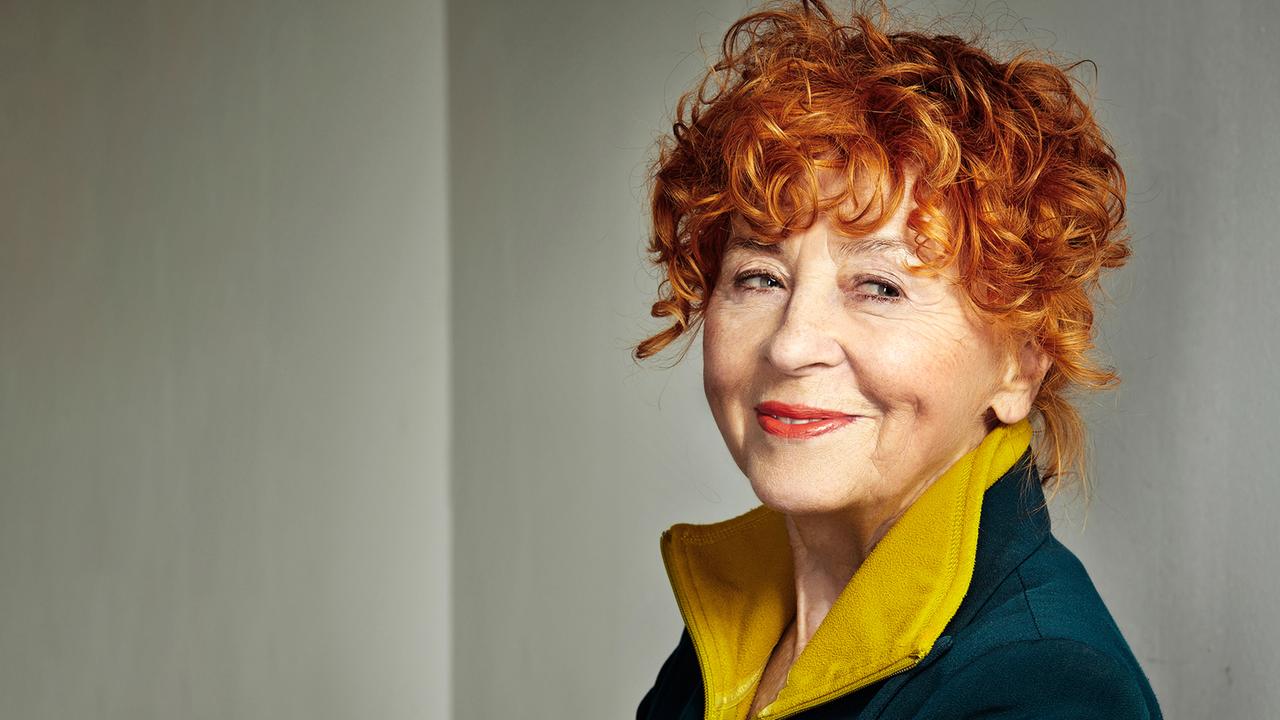 Fotografin Herlinde Koebl im Seitenprofil mit roten Haaren und einem Lächeln auf den Lippen