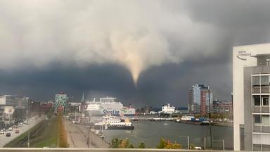 Ein Tornado wirbelt gut sichtbar vor dem Hafenbecken Kiels herum