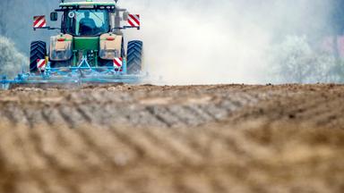 Traktor fährt auf einem Feld