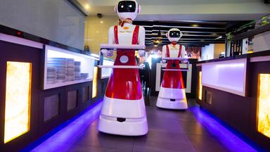 Roboter mit Tablett auf dem Weg zu Tischen