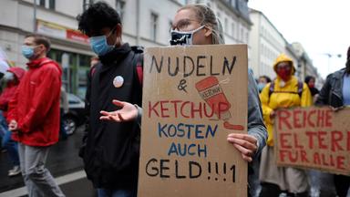 Auf einer Demonstration hält eine Studentin den Spruch hoch: "Spaghetti und Ketschup kosten auch Geld"