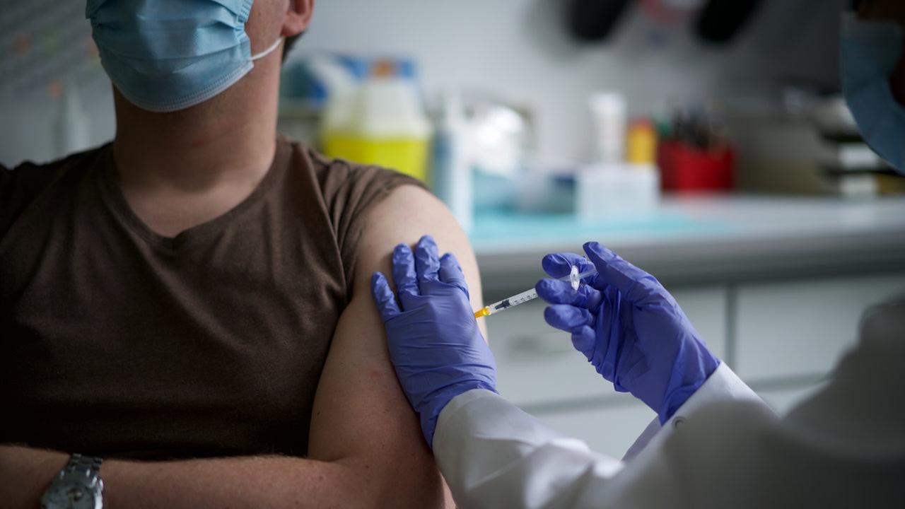 Persond wird in den Oberarm gespritzt