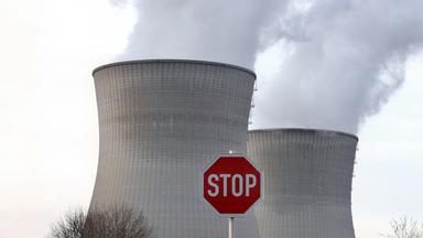 Atomkraftwerkt mit Stoff-Schild im Vordergrund