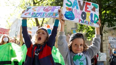 Prostestierende Kinder halten Schilder hoch