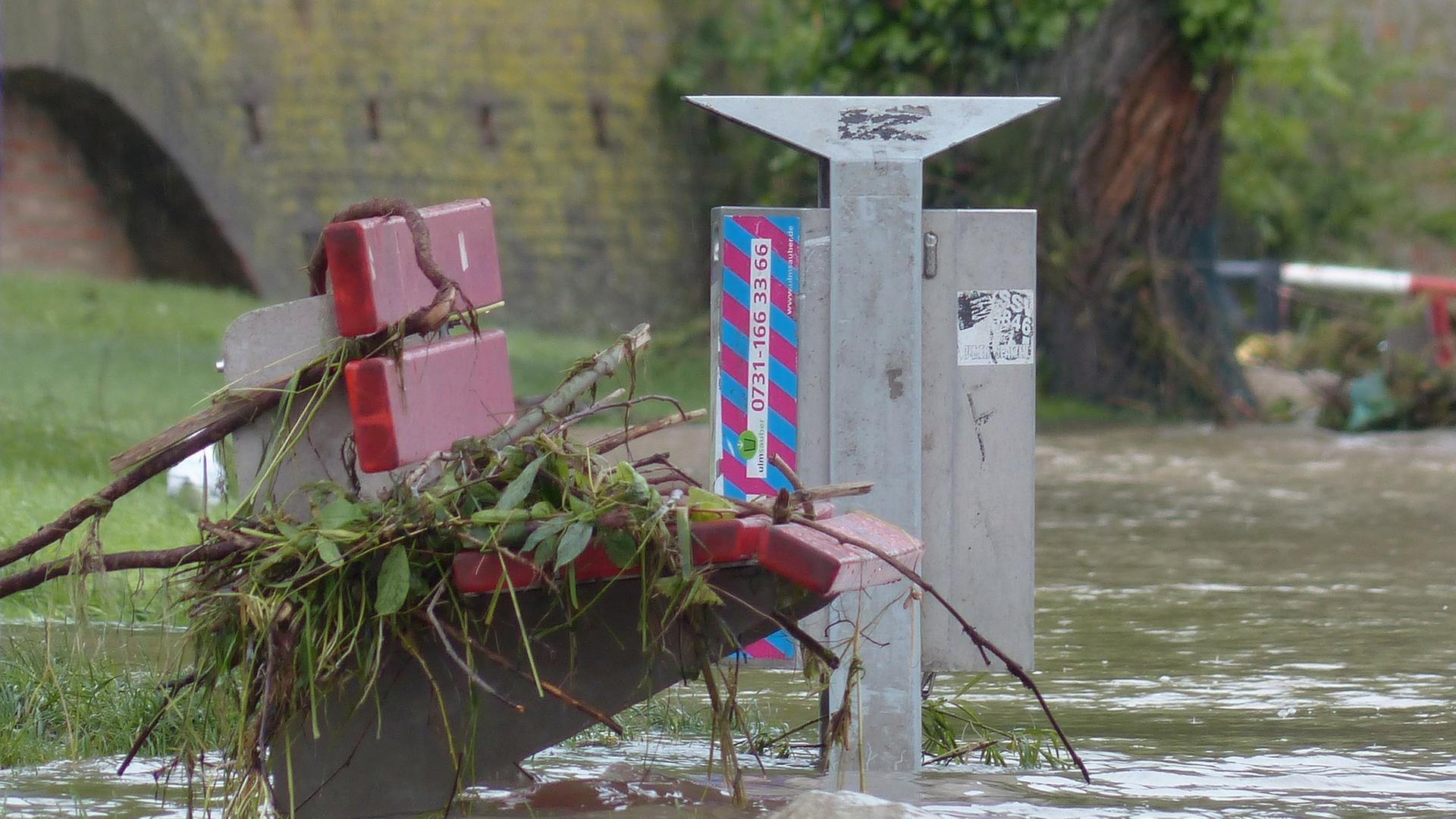 Bank mit Laub unter Wasser