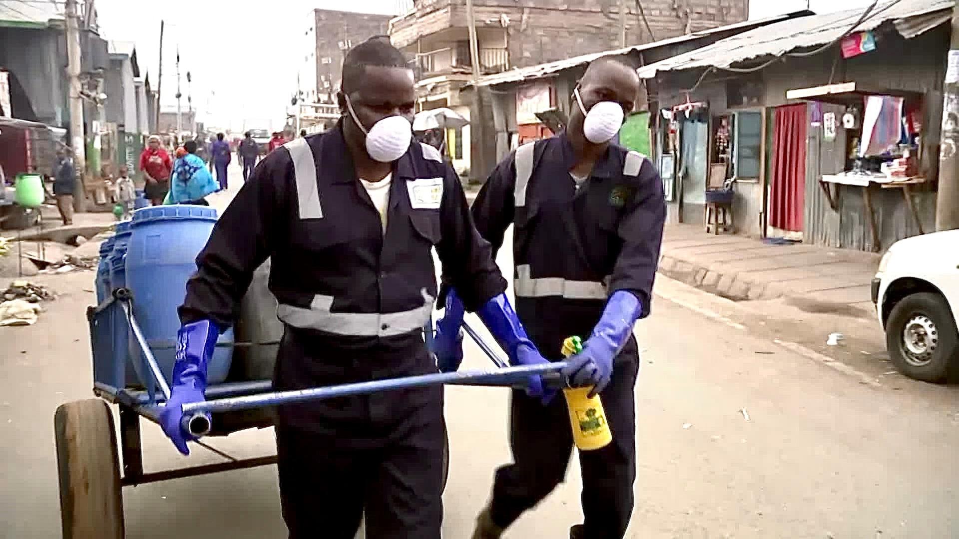 Slum in Nairobi: Männer transportieren blaue Fässer