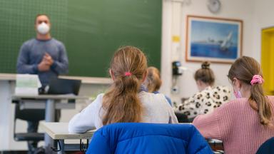 Zwei Schülerinnen von hinten in einem Klassenzimmer