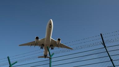 Flugzeug fliegt über einen Zaun