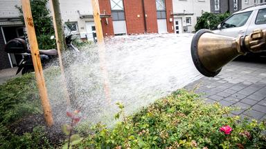 Wasser aus einem Schlauch wird auf Straße gespritzt