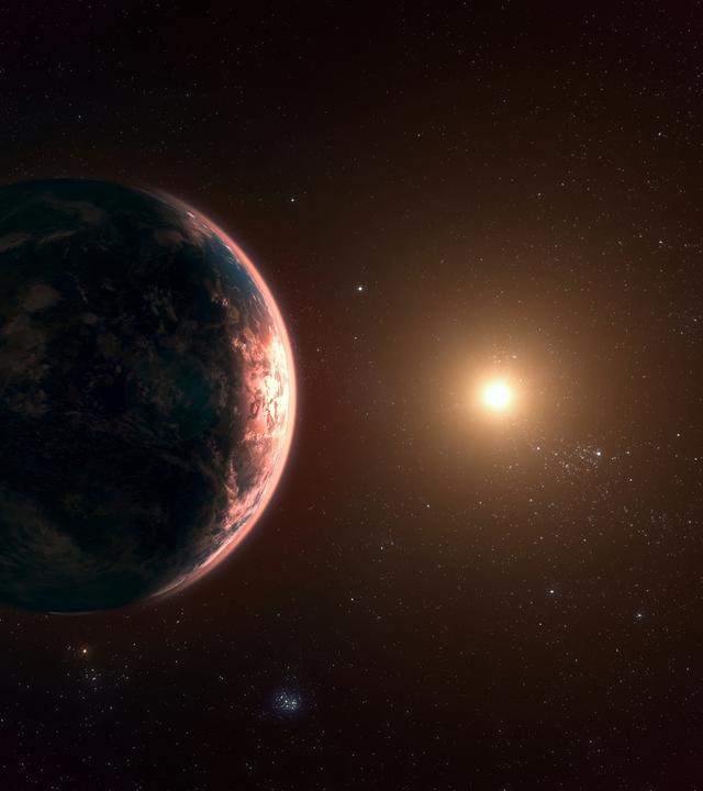 Eine Computeranimation zeigt einen fremden Planet in einem fremden Planetensystem. Seine Atmosphäre schimmert rötlich.