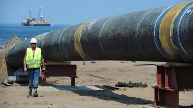 Nord Stream Gas-Pipeline am Ostseestrand in Lubmin. Im Hintergrund das Verlegeschiff.