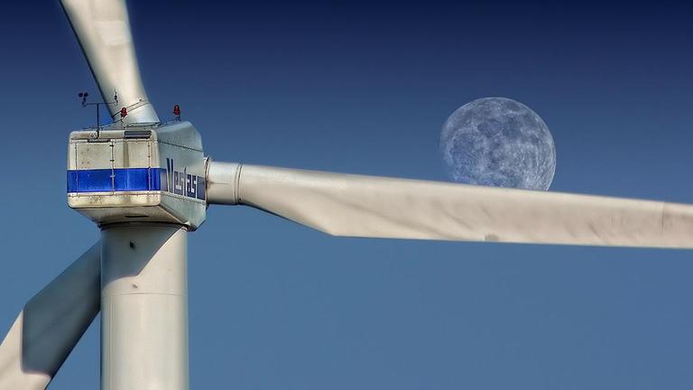Windkraftrad, nah mit Mond im Hintergrund