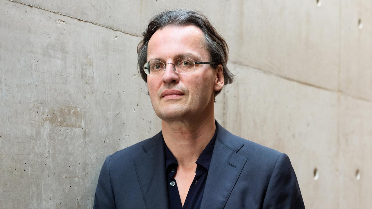 Bernhard Pörksen trägt eine Brille, ein dunkles Sacko und blickt in die Kamera