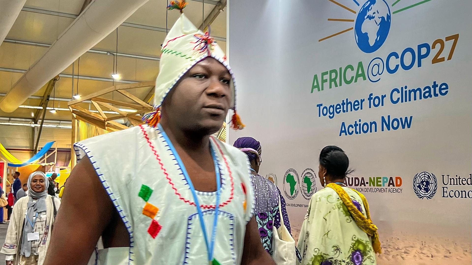 Klimakonferenz:  Menschen vor dem Logo "COP27"