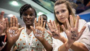 Aktivisten zeigen ihr Hände, auf die eine Botschaft geschrieben wurde