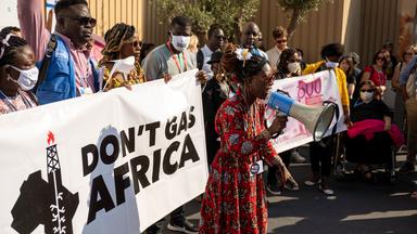 Demonstransten auf einer Straße halten Banner vor sich