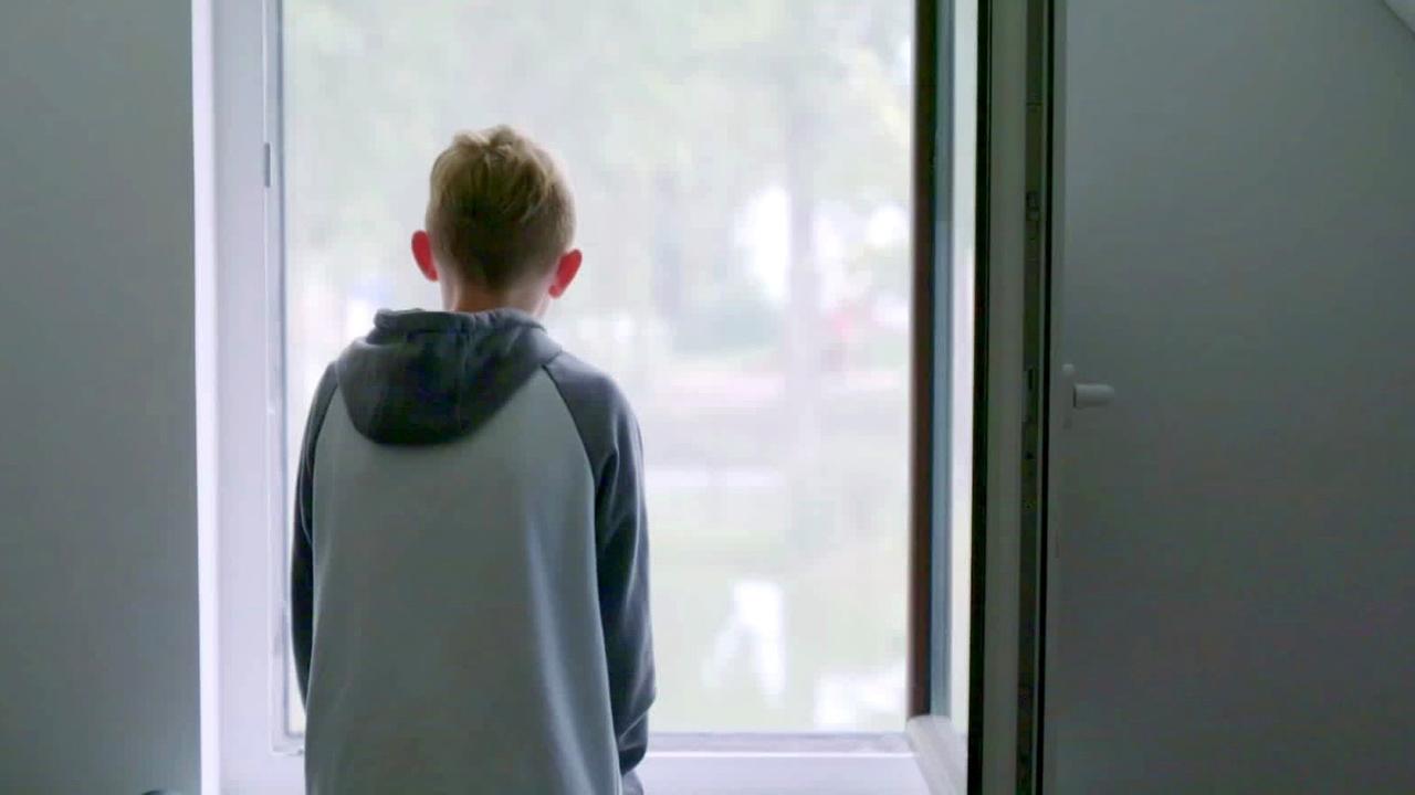 Junge von hinten am Fenster