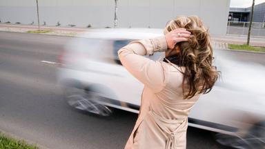 Frau hält sich wegen Verkehrslärm die Ohren zu