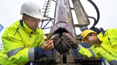 Mit Industriediamanten besetzt ist der Bohrkopf für die erste hessische Geothermie-Bohrung, den Mitarbeiter einer Spezialfirma vor dem Einsatz justieren.