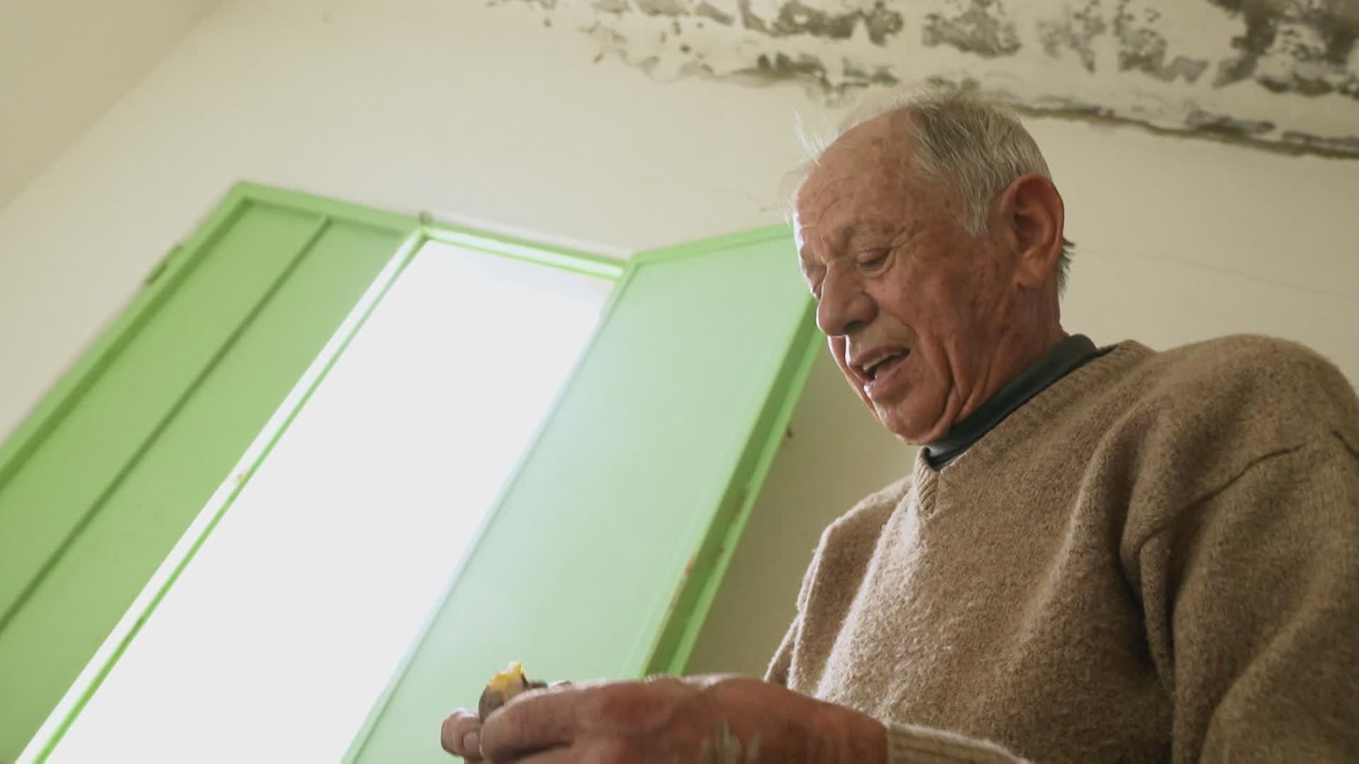 Älterer Mann beim Kartoffel schälen