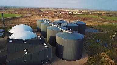 Schwarze, zylinderförmige Fermenter einer Biogasanlage in Dänemark