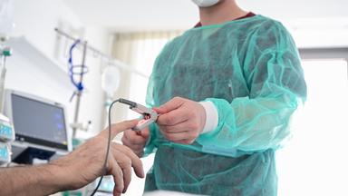 Pfleger am Bett eines Patienten