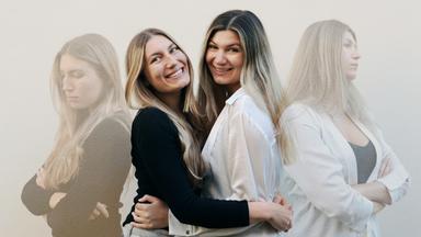  Zwei Schwestern umarmen sich. In einer zweiten, transparenten Bildebene wenden sie sich voneinander ab.