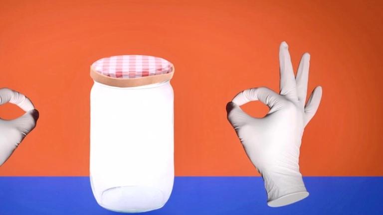 Animation: Marmeladenglas mit Gummiring, daneben Hände