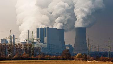 Dichte Wolken steigen aus den Kühltürmen und Schornsteinen des RWE-Braunkohlekraftwerks in Neurath, NRW
