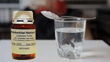 Tödliches Medikament neben einem Glas Wasser