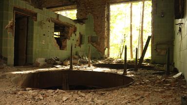 Das Innere einer völlig heruntergekommenen Brauerei-Ruine im brandenburgischen Wiesenburg. Im Vordergund klafft ein großes, rundes Loch im Boden, im Hintergrund blickt man duch einen großen Duchbruch ins Freie.