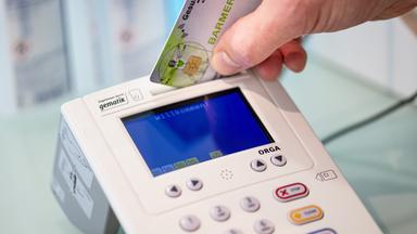 Krankenkarte wird in einen Kartenleser eingesteckt