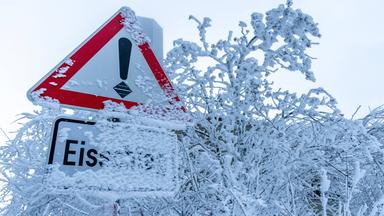 Schild unter Eisschicht fast verborgen