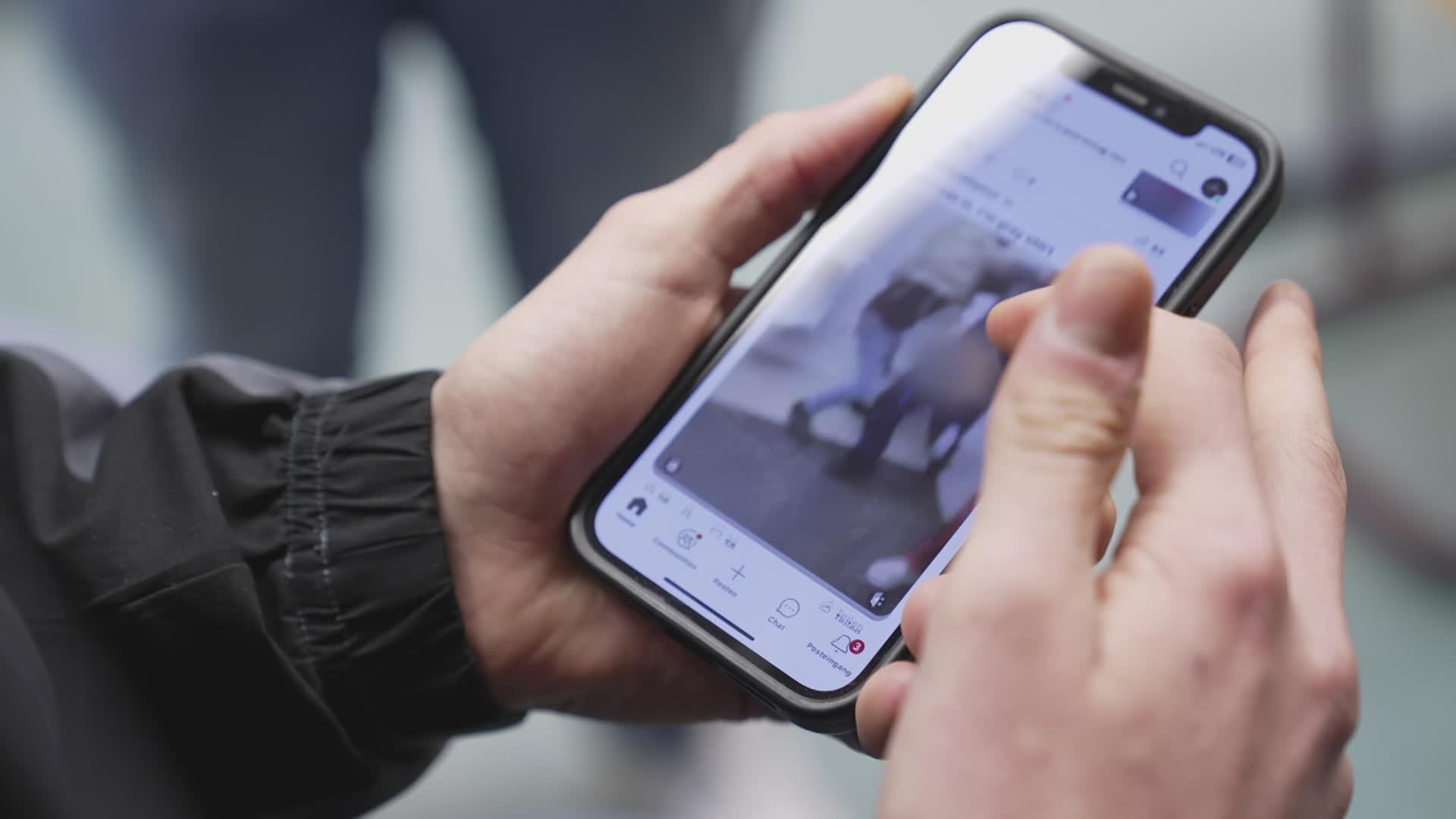 Hand hält Smartphone auf dem Gewaltvideo läuft