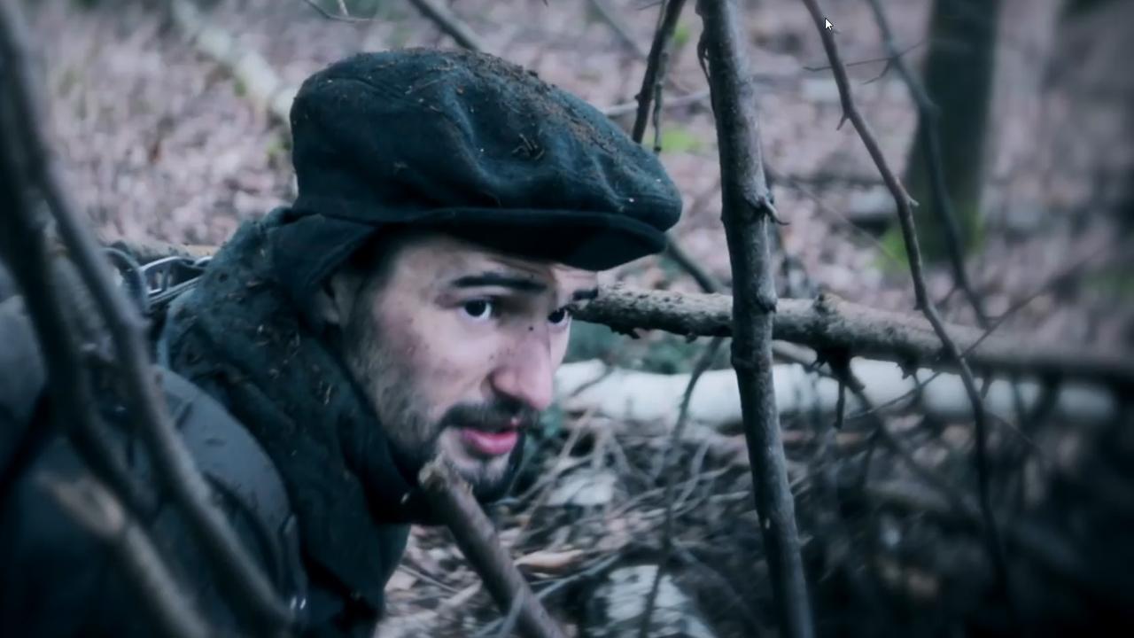 Mann versteckt sich im Gestrüpp