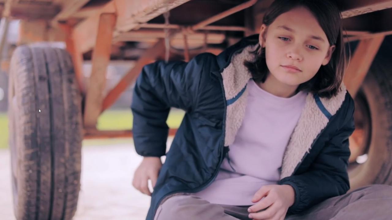 Mädchen sitzt unter einem Hänger