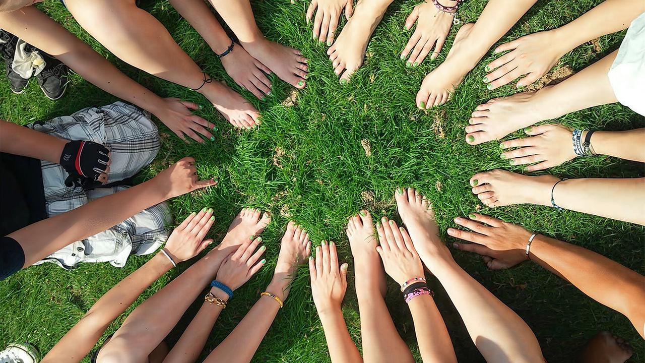 Hände und nackte Füße  in einem Kreis 