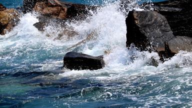 Wellen peitschen an einen Felsen